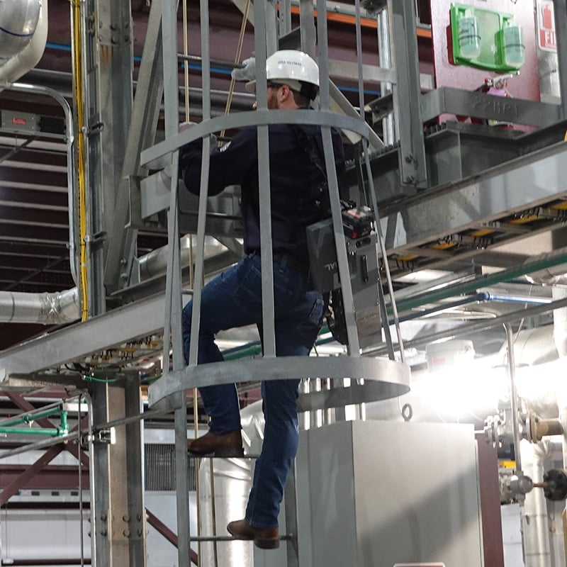 Radiographer climbing through tight space with folded OpenVision HD 