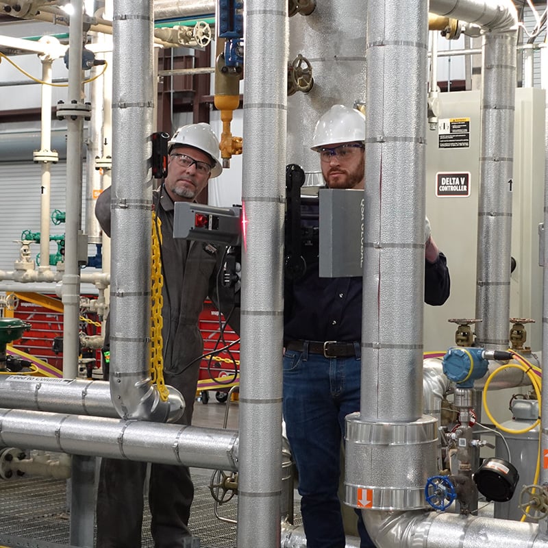 Radiographer screening vertical piping system with OpenVision HD and the Image Stabilizer while the other radiographer shows the results on a tablet